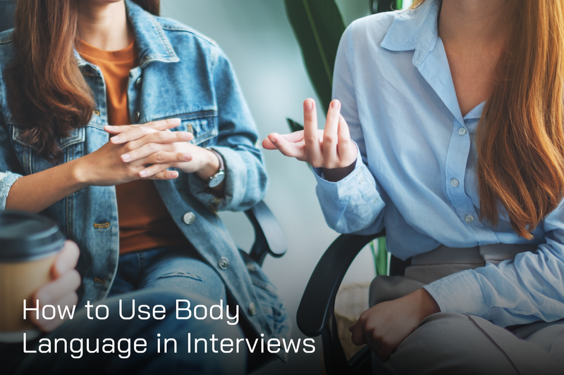 how to use positive body language in interview text in white and two girls having conversation in the backgraound